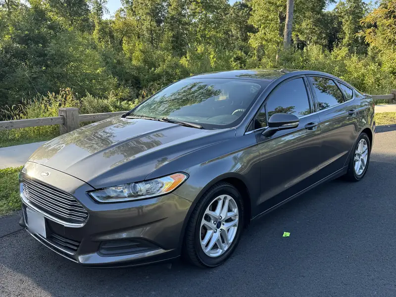 Grey Ford Fusion sedan with black interior, front three-quarter view, parked in evening light