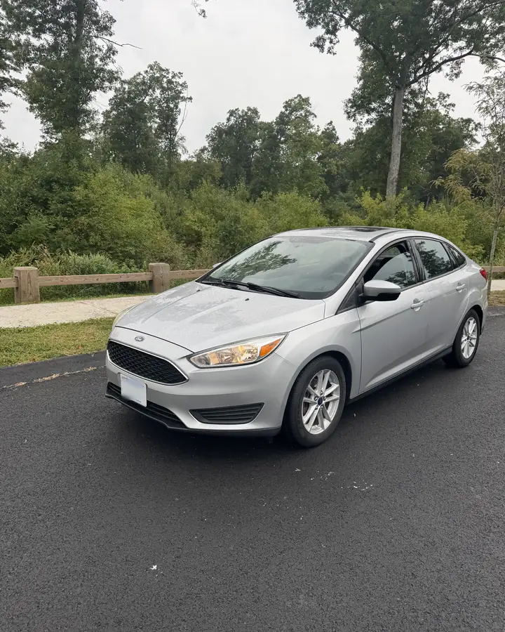 Silver Ford Focus sedan on a curved road