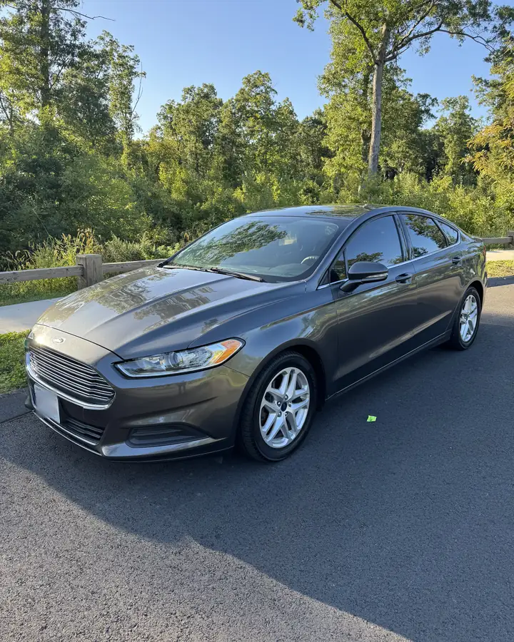 Grey Ford Fusion sedan with black interior, front three-quarter view